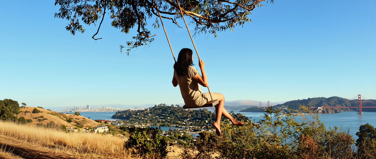 A woman on a rope swing overlooking the water